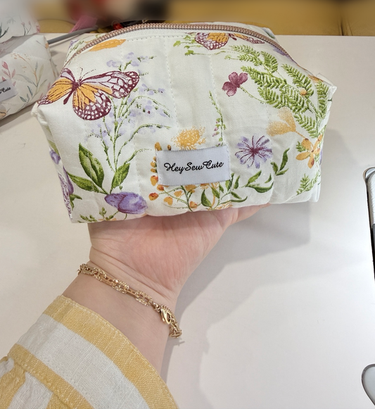 Daily Muse butterfly handmade makeup bag held in hand with original table and natural shadow