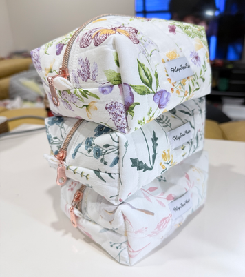 Three Daily Muse Garden Series makeup bags stacked naturally in the maker's sewing space