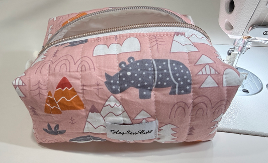Pink Safari quilted makeup bag with grey rhino and mountain print, front view